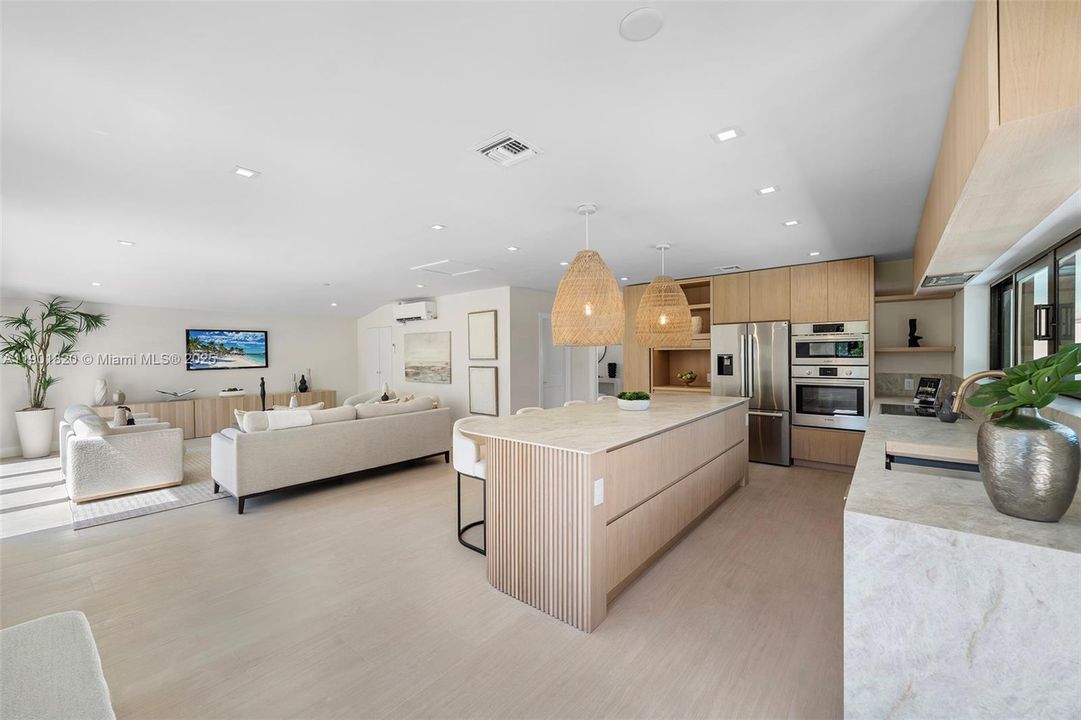 he stunning new kitchen, with a unique island bar design, flows seamlessly into the spacious playroom for modern family living
