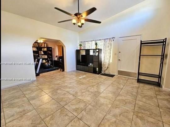 Livingroom and entrance to home with view of extra room used as a library / gym