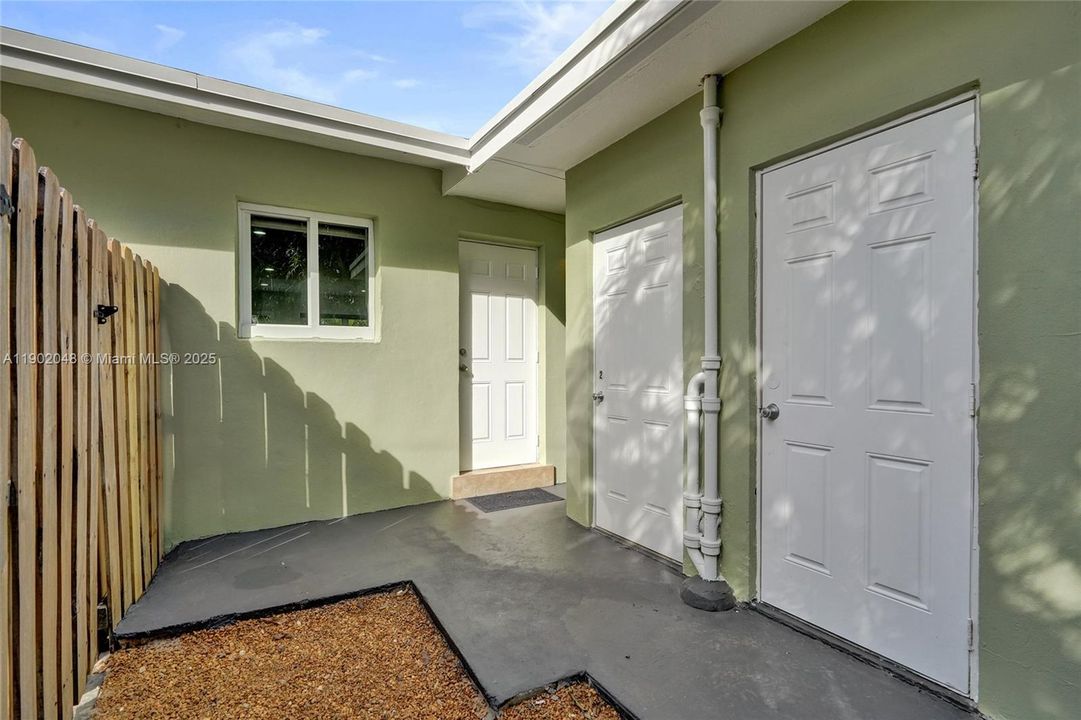 Exterior door by unit 2's kitchen takes you out to private laundry room/storage behind right side door.