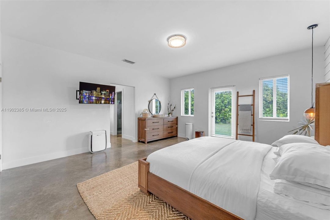 LARGE PRIMARY WING W/ VIEWS OF THE PROPERTY & THE HOME, WITH IMPACT DOORS LEADING TO THE PROPERTY, BEAUTIFULLY COORDINATED ORGANIC FIXTURING & POLISHED FLOORS, ALSO A LARGE SITTING AREA/OFFICE OFF THE SUITE.