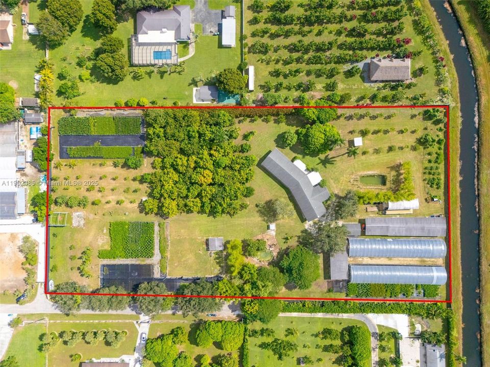 5 ACRE AERIAL VIEW OF THE FULLY REMODELED  4/3.5 HOME W/ 2 CAR GARAGE 4 BAY CAR PORT, SHADE HOUSES, & WATER FEATURES. ALL SITTING ON A QUIET CUL DE SAC BACKING UP TO A CANAL.