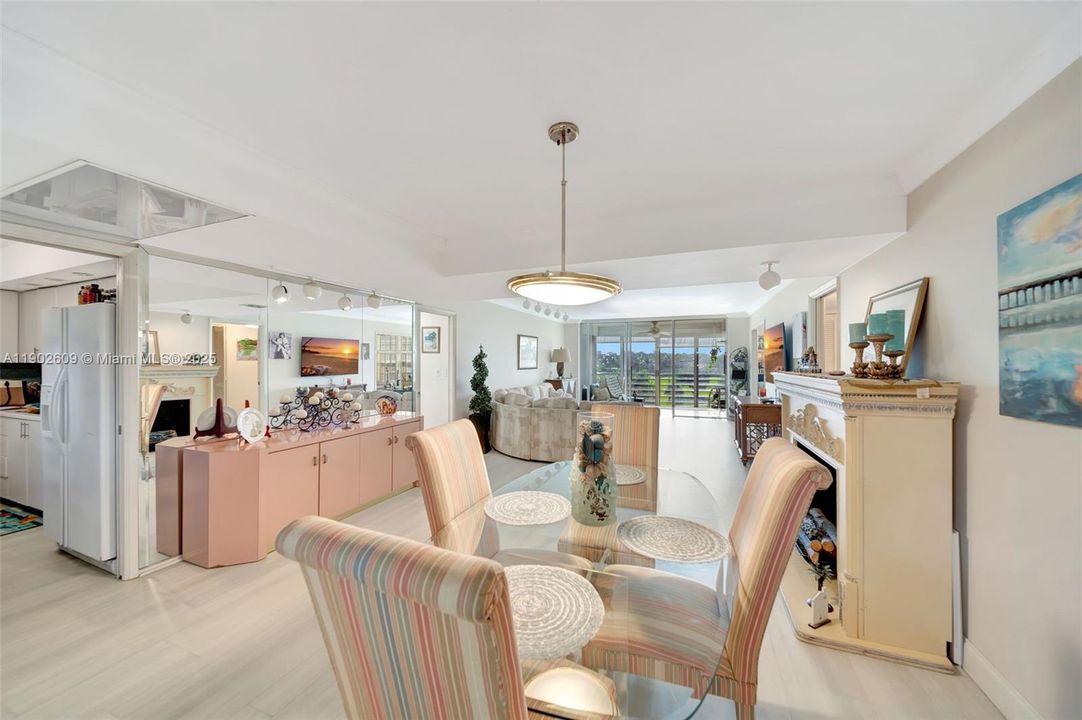 Open-concept dining and living space designed for entertaining, with crown accents, generous ceiling height, and seamless flow into the kitchen and out to the view.