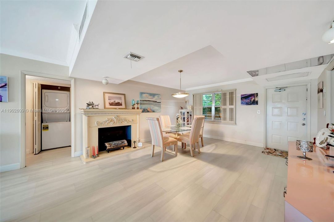 Elegant dining area anchored by a detailed mantle and faux-fireplace feature, plus the convenience of an in-unit laundry tucked just off the main living space.