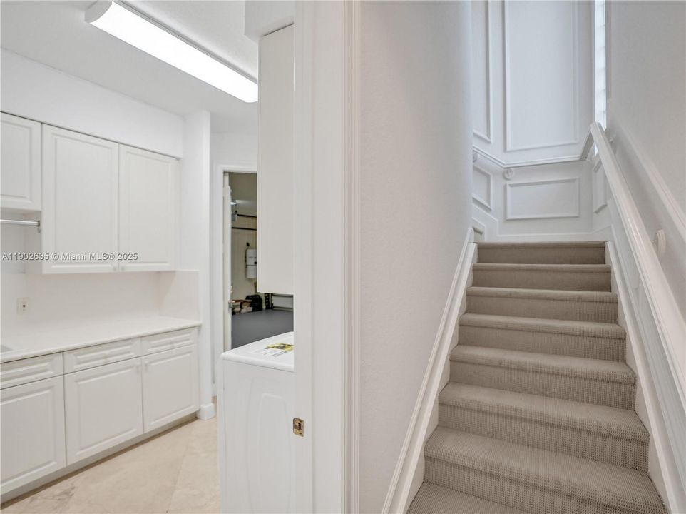 Stairs to bonus room and 3 bedrooms. Left side is laundry