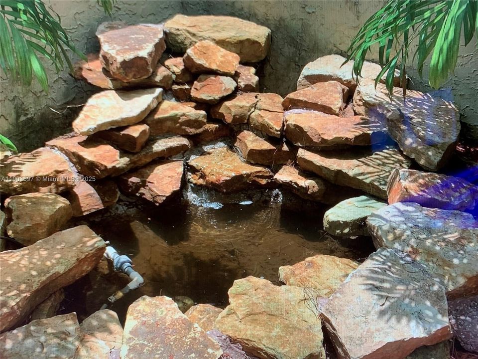 Attractive pool has cascading waterfall.