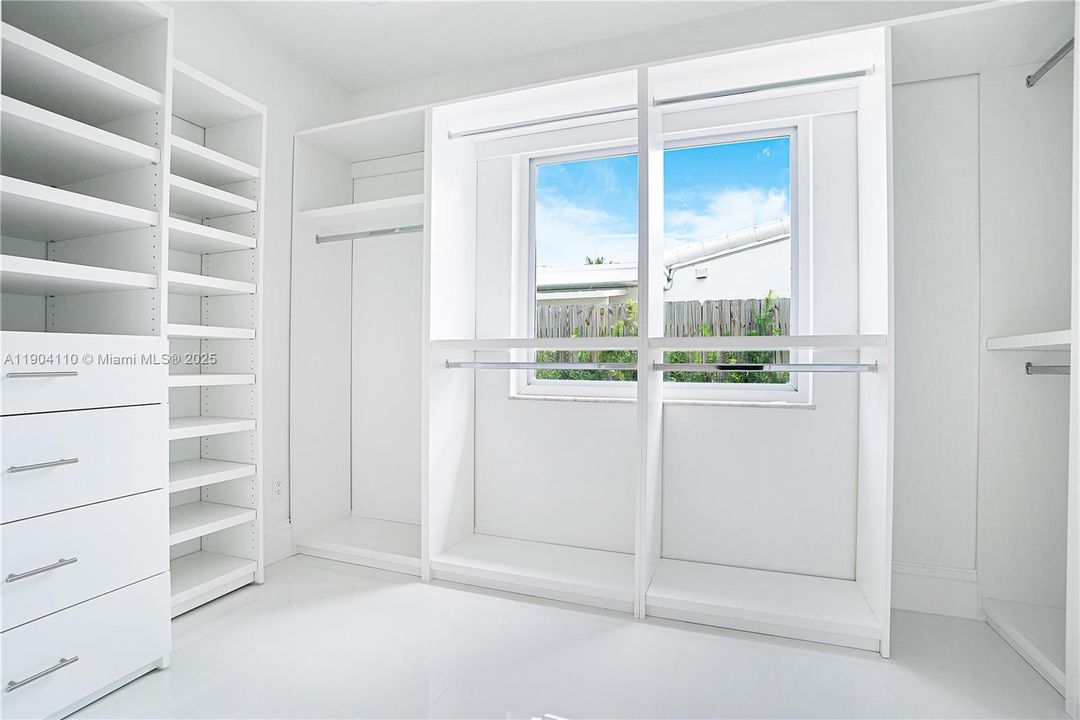 Extensive Cabinetry in Primary Bedroom Closet with Daylight