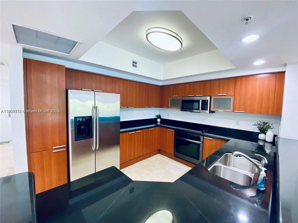 Open kitchen with stainless steel appliances and extra cabinets space