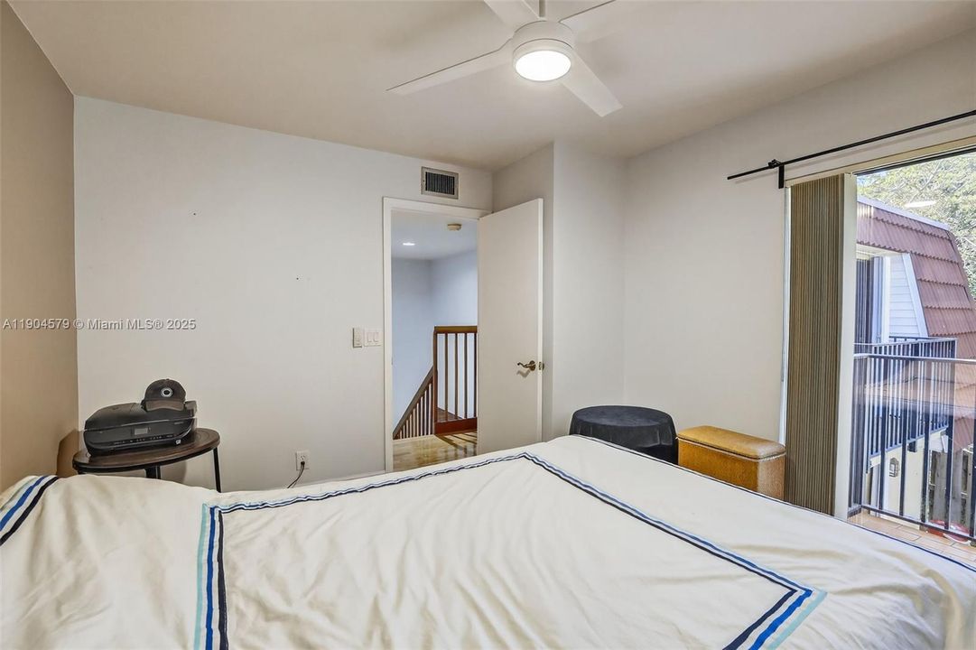Comfortable guest bedroom with its own private balcony and plenty of natural light.