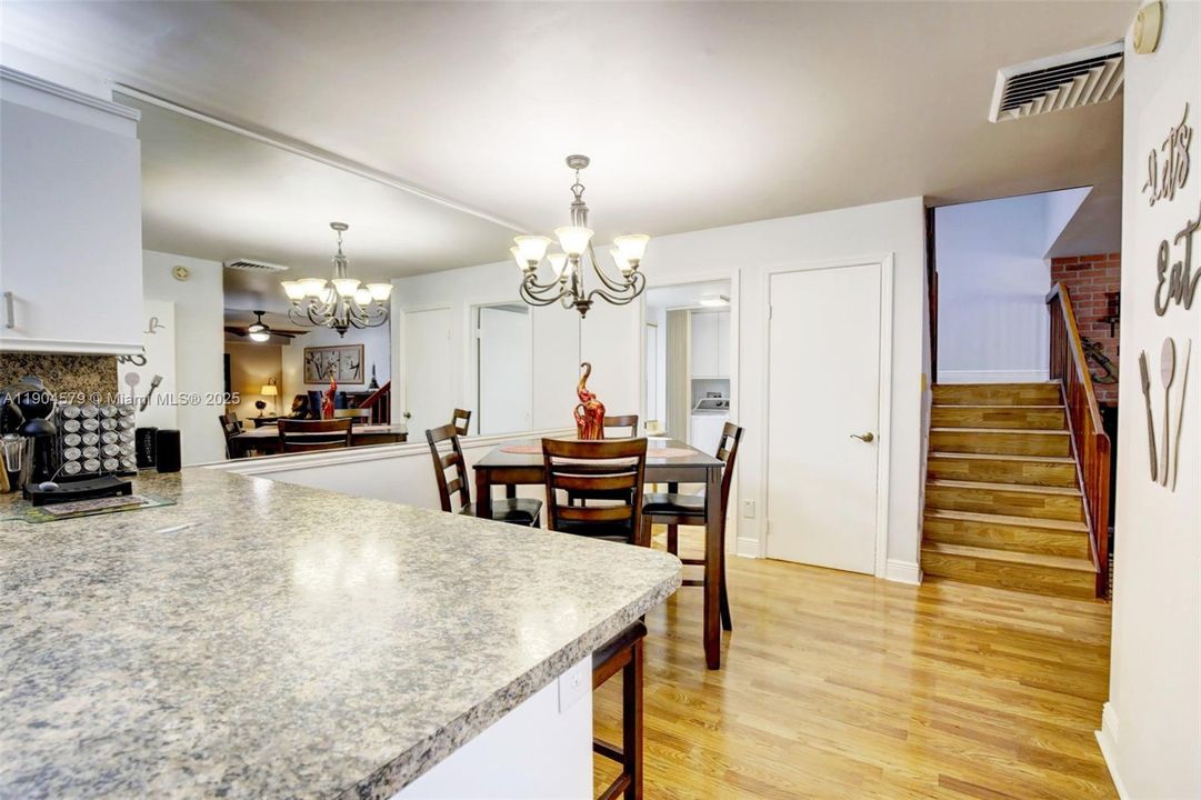 Large counter w/ breakfast bar. Custom mirror makes the dining area feel even larger. Guest bathroom behind w/ washer / dryer. Storage closet under the stairs. Flat ceilings.