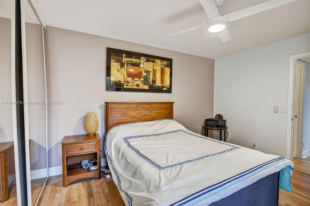 Comfortable guest bedroom with laminate flooring, its own private balcony and plenty of natural light.