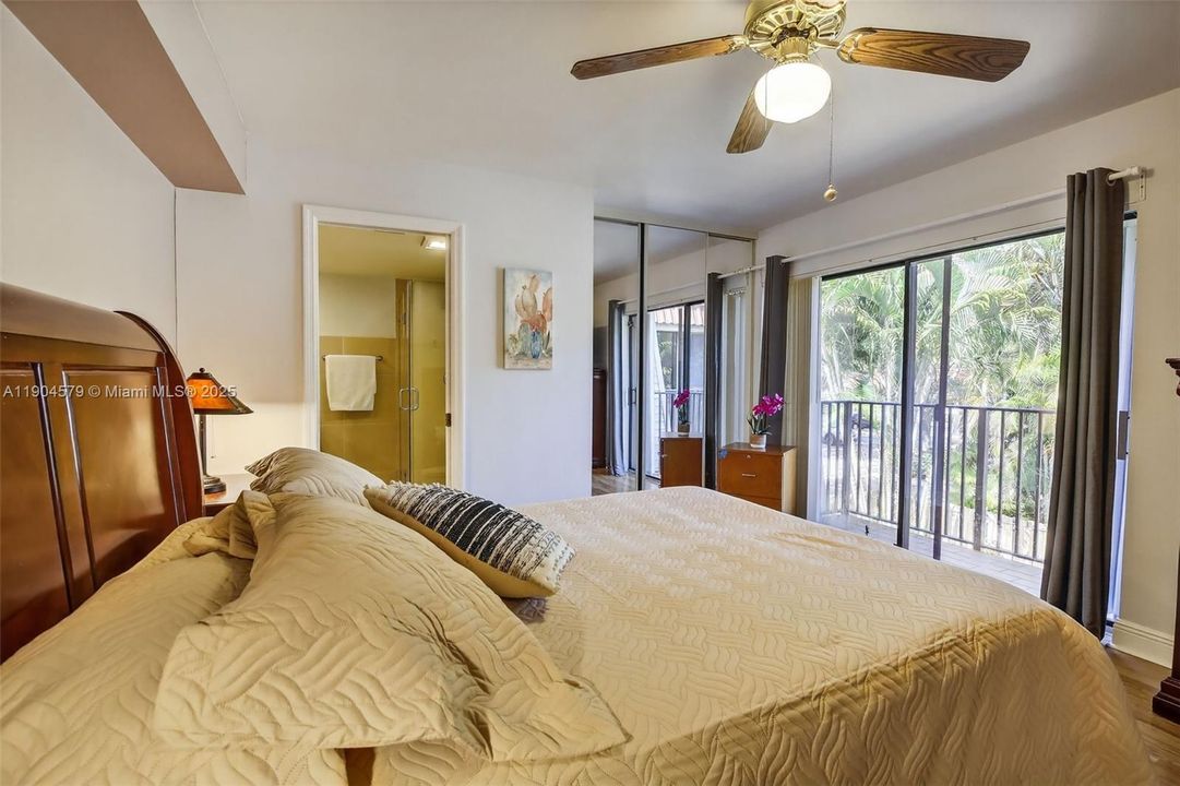 Large primary bedroom with private balcony, walk in closet and serene garden views.