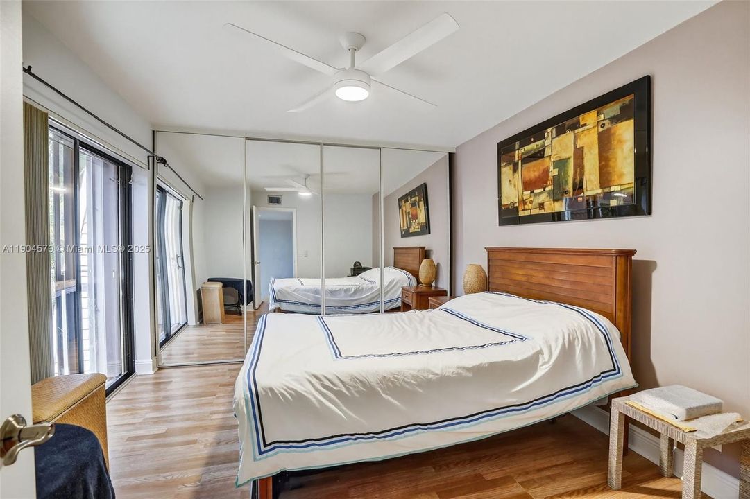 Comfortable guest bedroom with laminate flooring, its own private balcony and plenty of natural light.