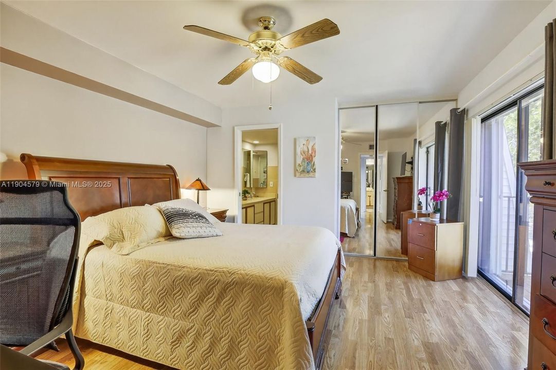 Large primary bedroom with private balcony, walk in closet and serene garden views.