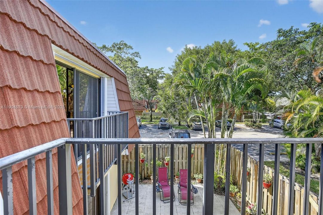 Dual private balconies overlooking the peaceful community greenery. Accordion shutters on windows.