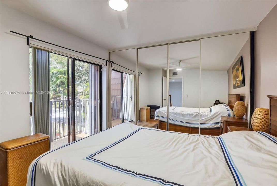 Comfortable guest bedroom with its own private balcony and plenty of natural light.