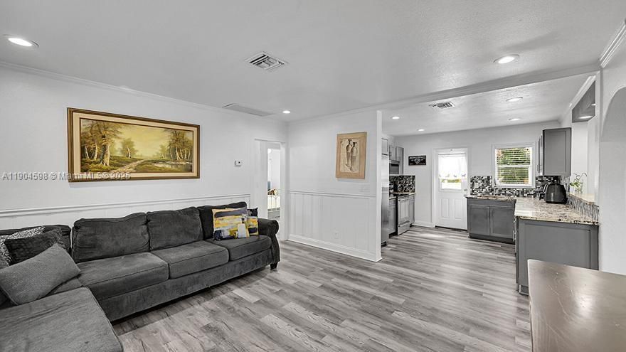 Arched Walkways, Baseboards Wall, Crown Molding, Drywall, Natural Light, Paneling Wall, Recessed Lighting, Textured Ceiling, U Shaped Kitchen, Vent, Wainscot Wall, Wood Finish Floor, Crown Molding, Wainscot Wall, Wood Finish Floor