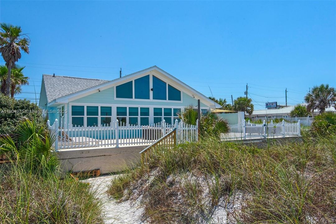 Coastal architecture meets comfort — classic beach cottage lines with impact windows and doors.