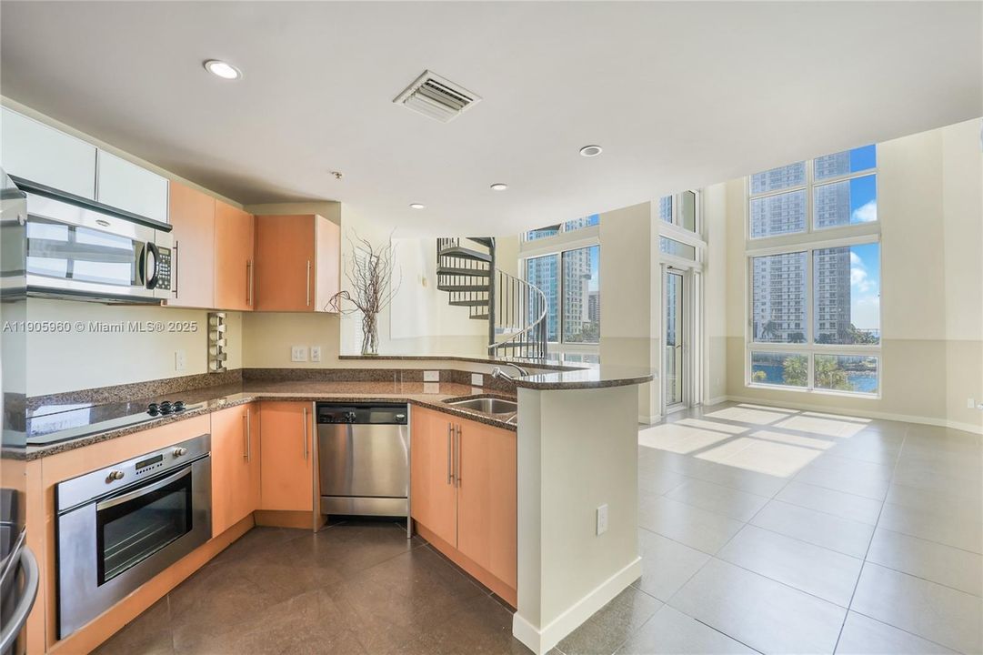 New refrigerator, oven, stove, microwave, dishwasher, and washer and dryer close by.