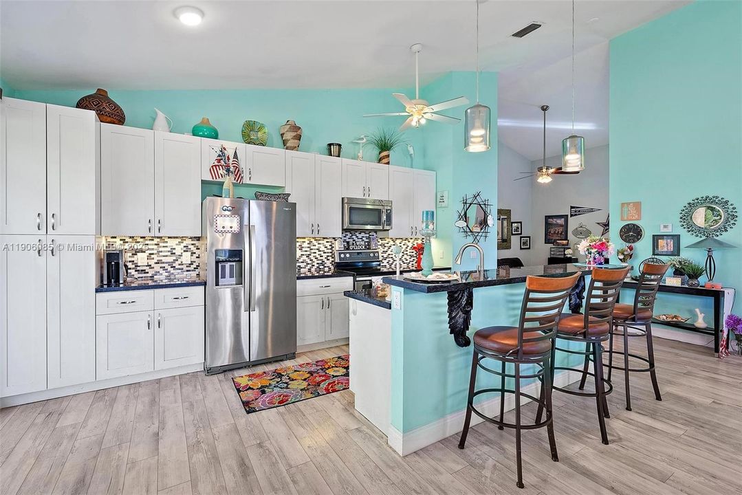 Remodeled Kitchen with granite counter tops and stainless-steel appliances. Opens to Dining area and Living room with vaulted ceilings.