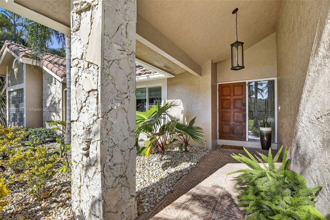 Large covered entry with coral stone accents