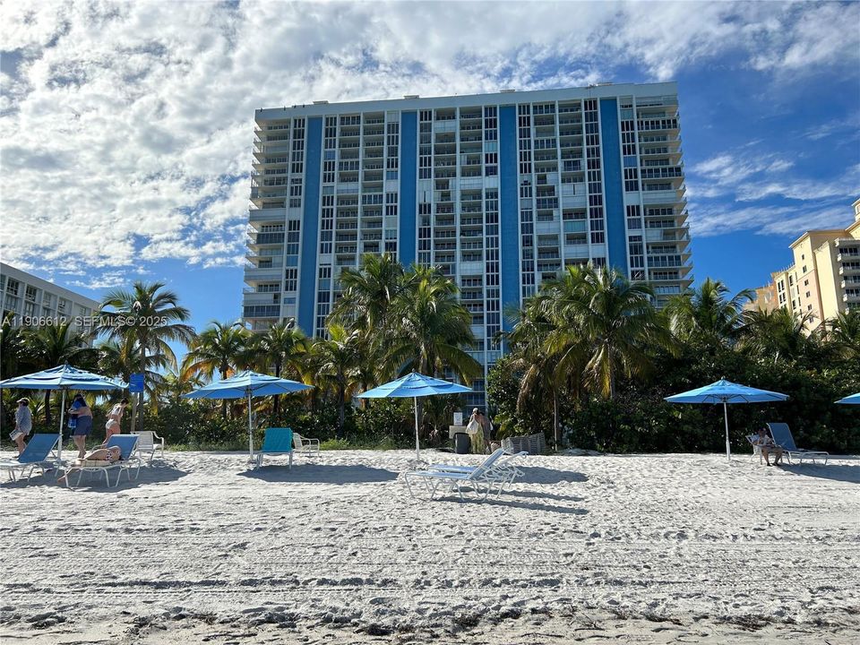 Resort-style oceanfront building as seen from the beach.