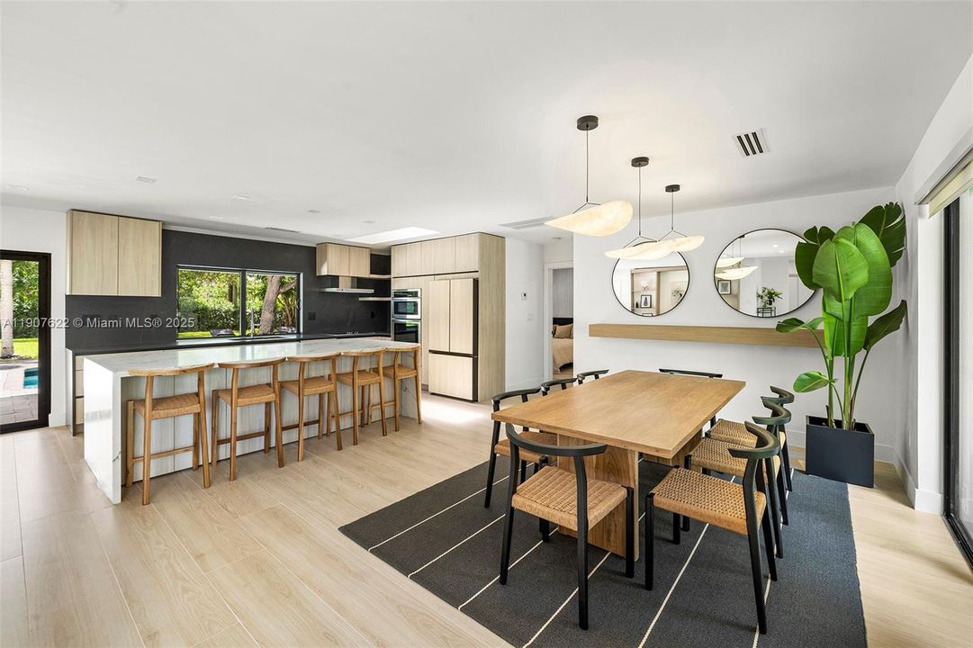 A sleek designer kitchen with a stunning oversized island opens into a bright dining area—perfectly integrated for everyday living and effortless entertaining.