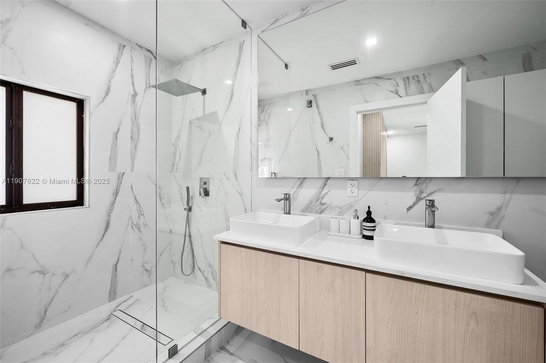 Third Bathroom features floor-to-ceiling porcelain slabs, a double vanity with vessel sinks, and a spacious walk-in shower—minimalist, elegant, and brand new.