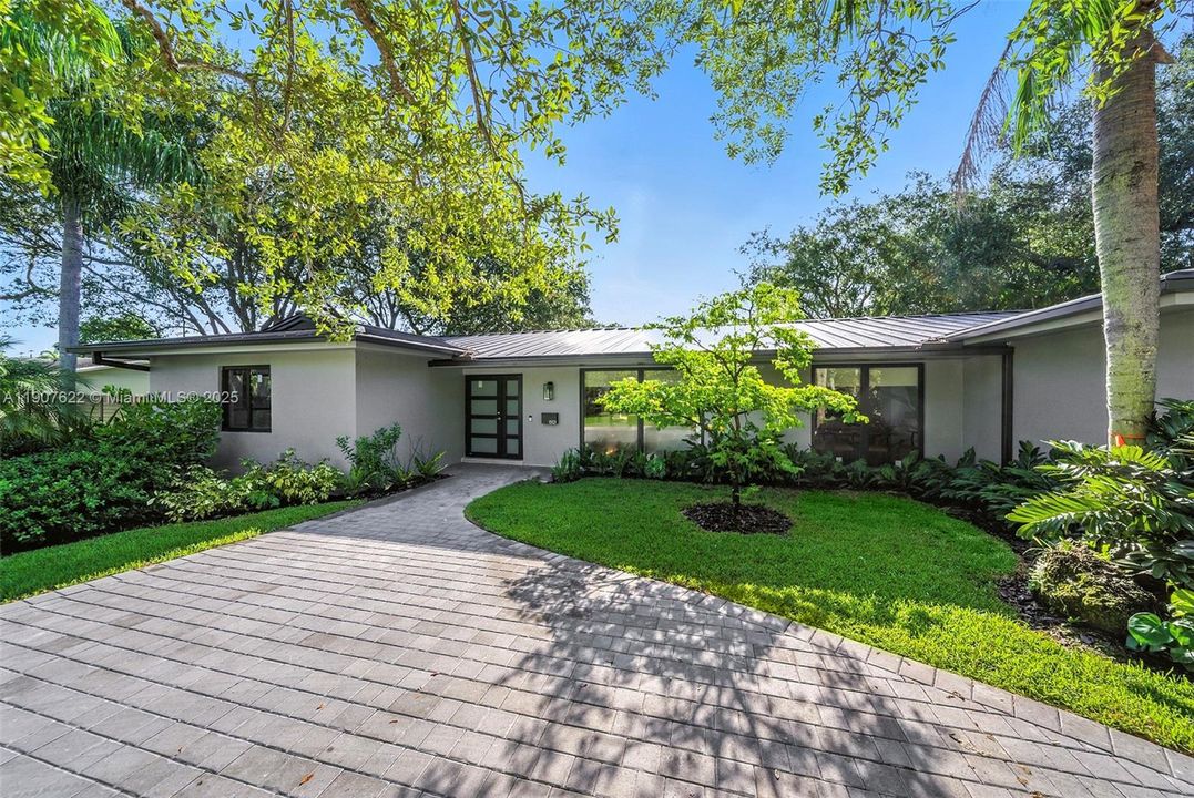 A wide, elegant entrance sets the tone for this fully rebuilt home—featuring a modern façade, sleek double front doors, and a gracious driveway that welcomes with style.