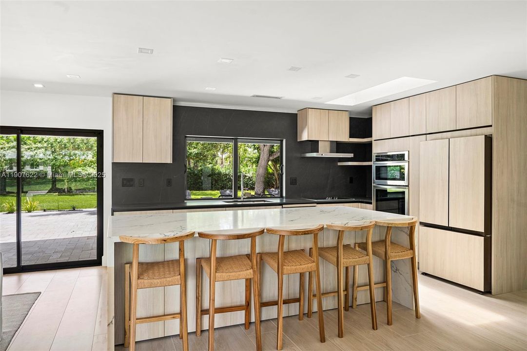 The oversized island not only features stunning quartz stone but also includes built-in storage below—seamlessly blending beauty and practicality.