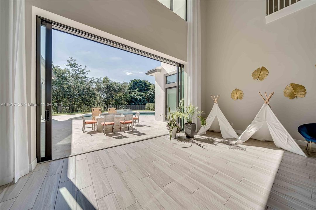 pocket sliding doors in great room opens up to fire pit and pool area. motorized screen equipped here as well.