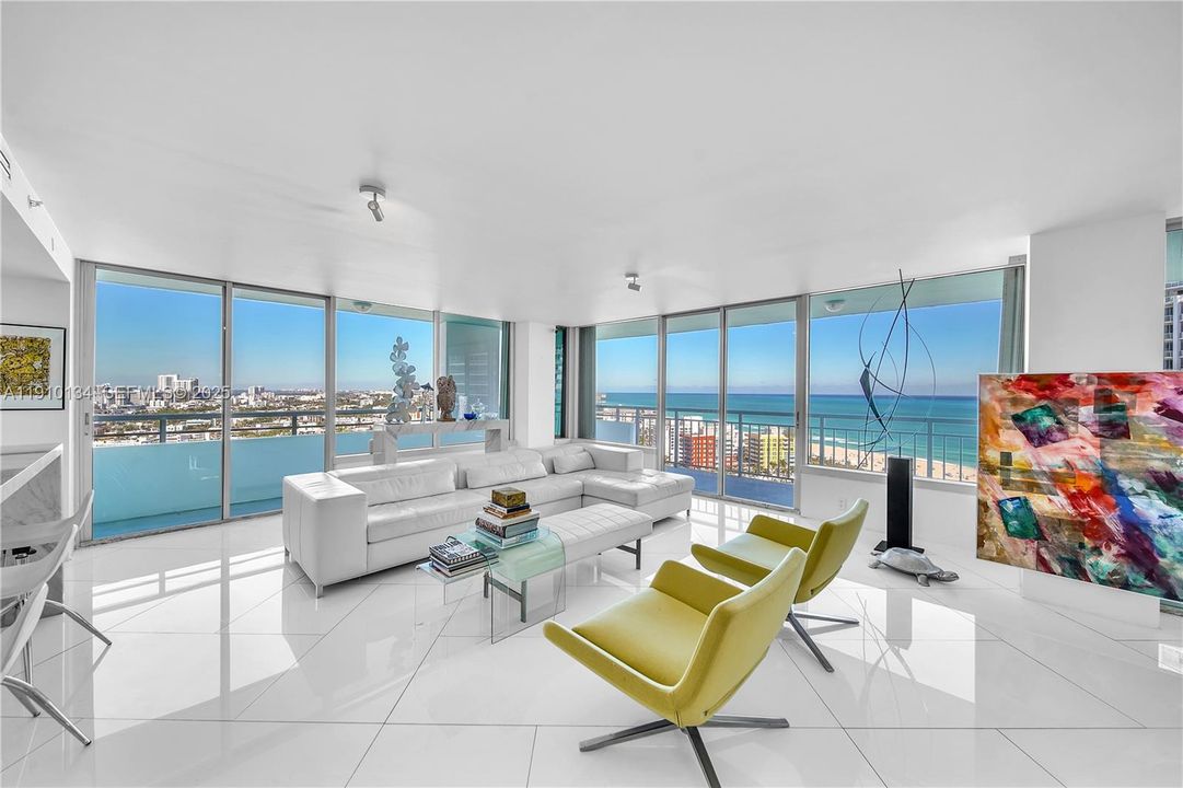 Walls of floor to ceiling glass frame the ocean, beach and SoBe skyline