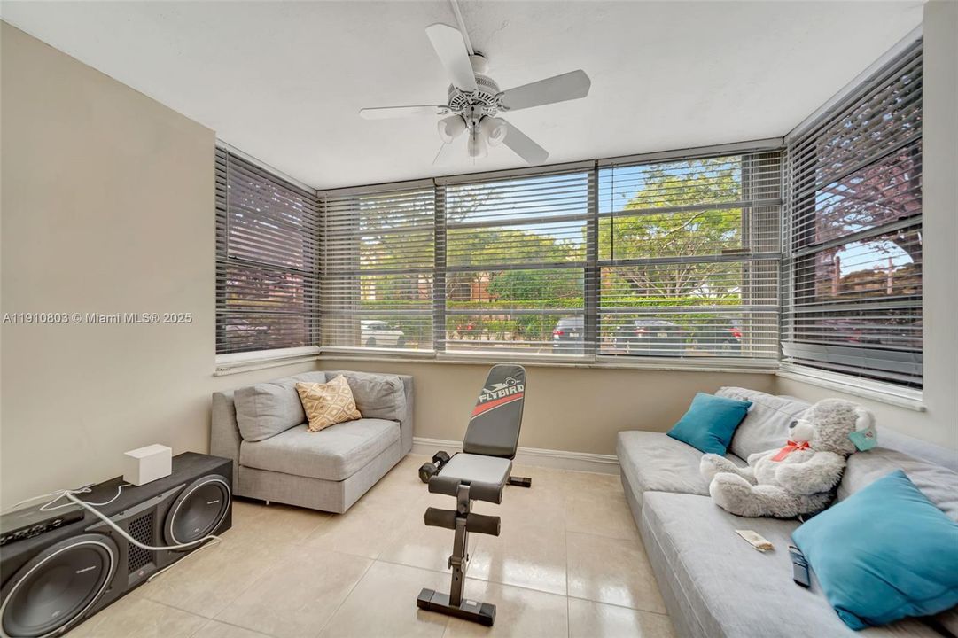 Extended Living Room area surrounded by windows. Has Accordion hurricane shutters