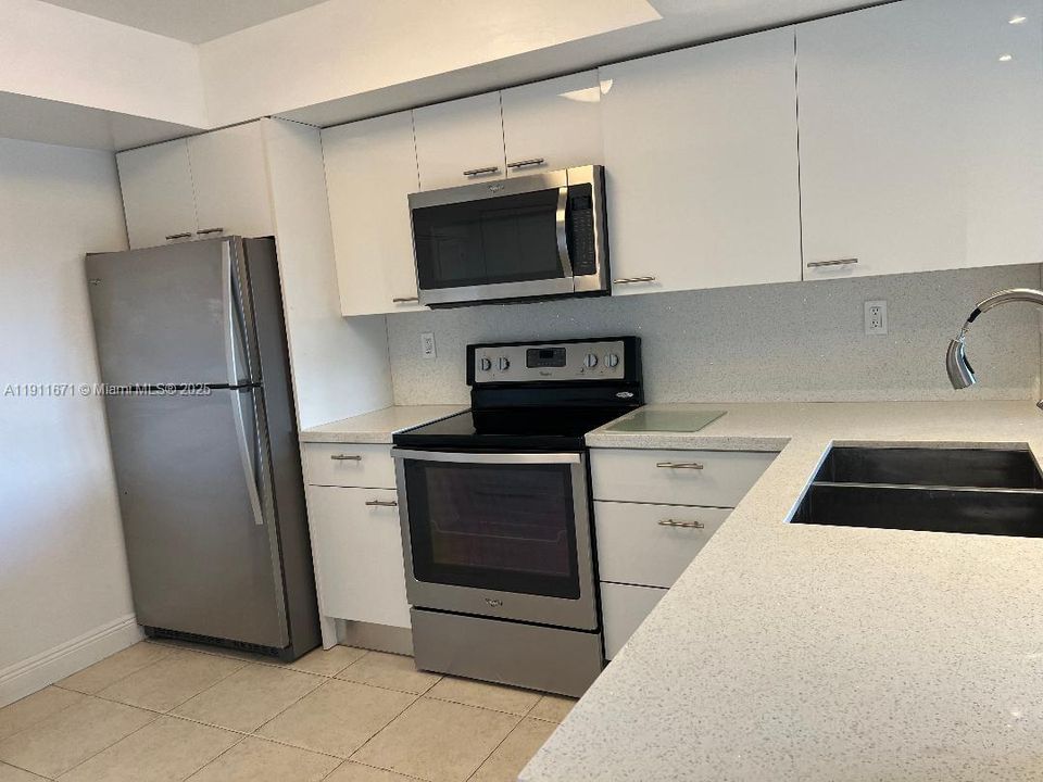 Stainless steel appliacnes. Dishwasher next to sink.