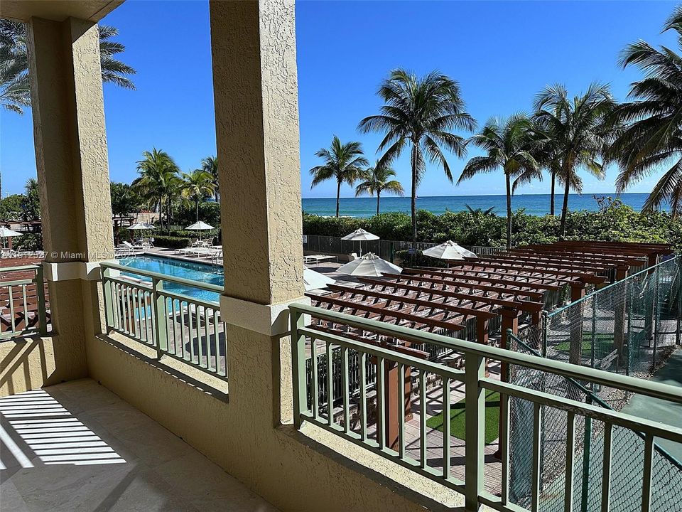 long balcony view of pool and ocean