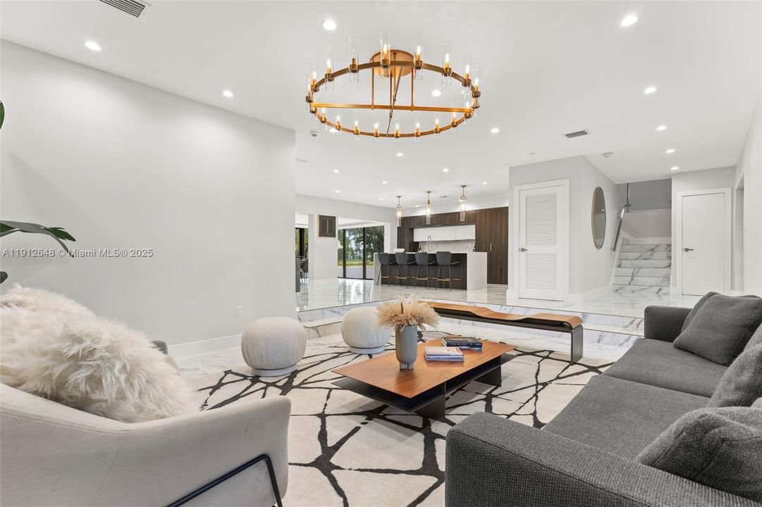 Living Room looking onto entrance to home, kitchen with large Quartz island and Dining Room.