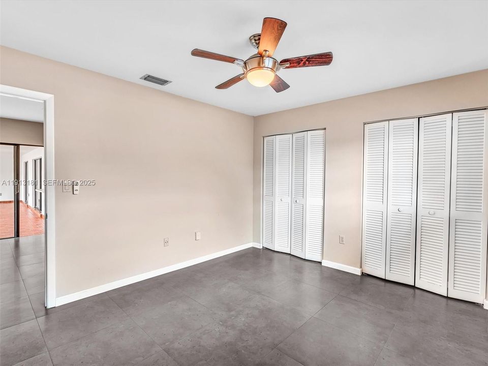 Bedroom 2 has ample closet space and a ceiling fan
