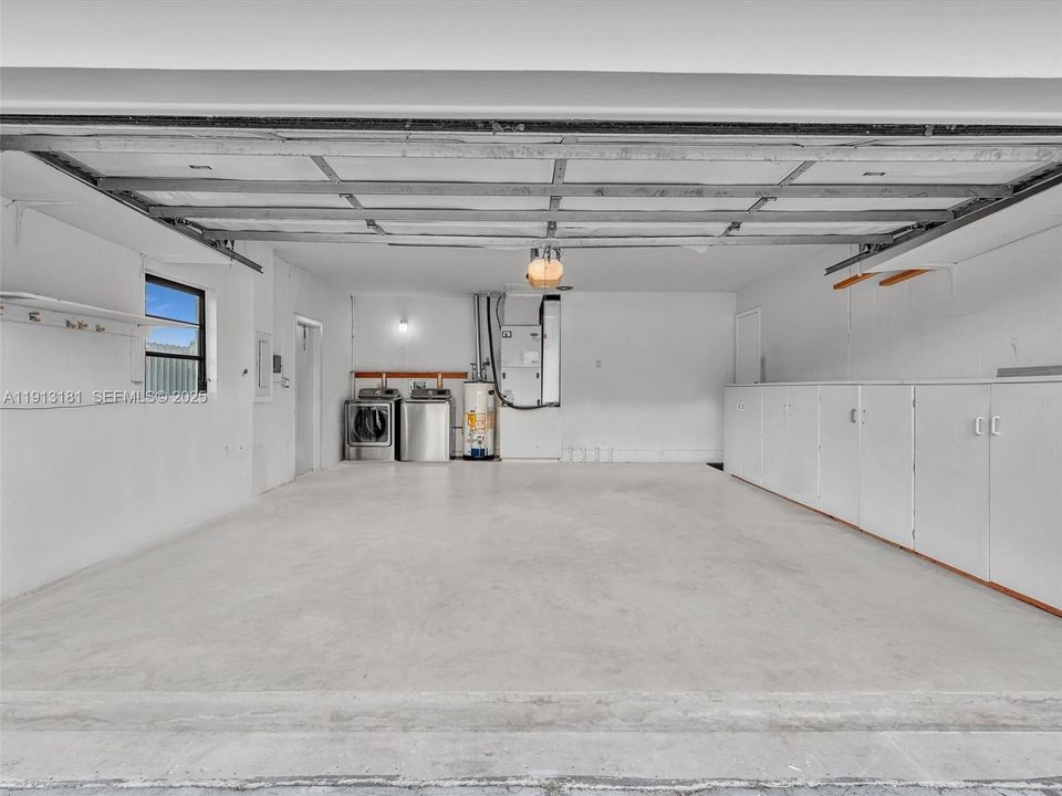 Garage features a gas powered Washer, Dryer and Water Heater. Custom built cabinetry and shelving exist for convenient storage