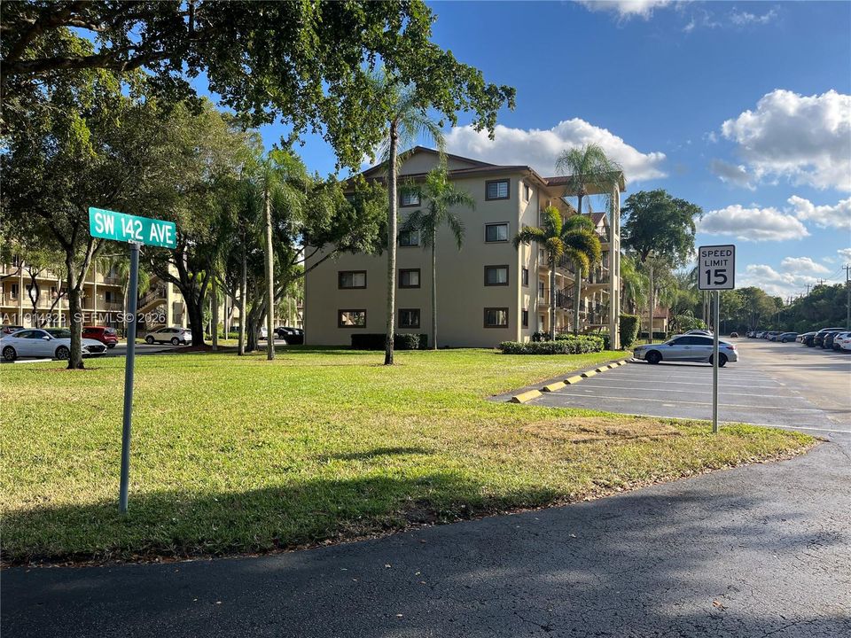 North end of bldg H - shows large green area and plenty of guess parking spaces - accordion shutters for unit on 3rd floor