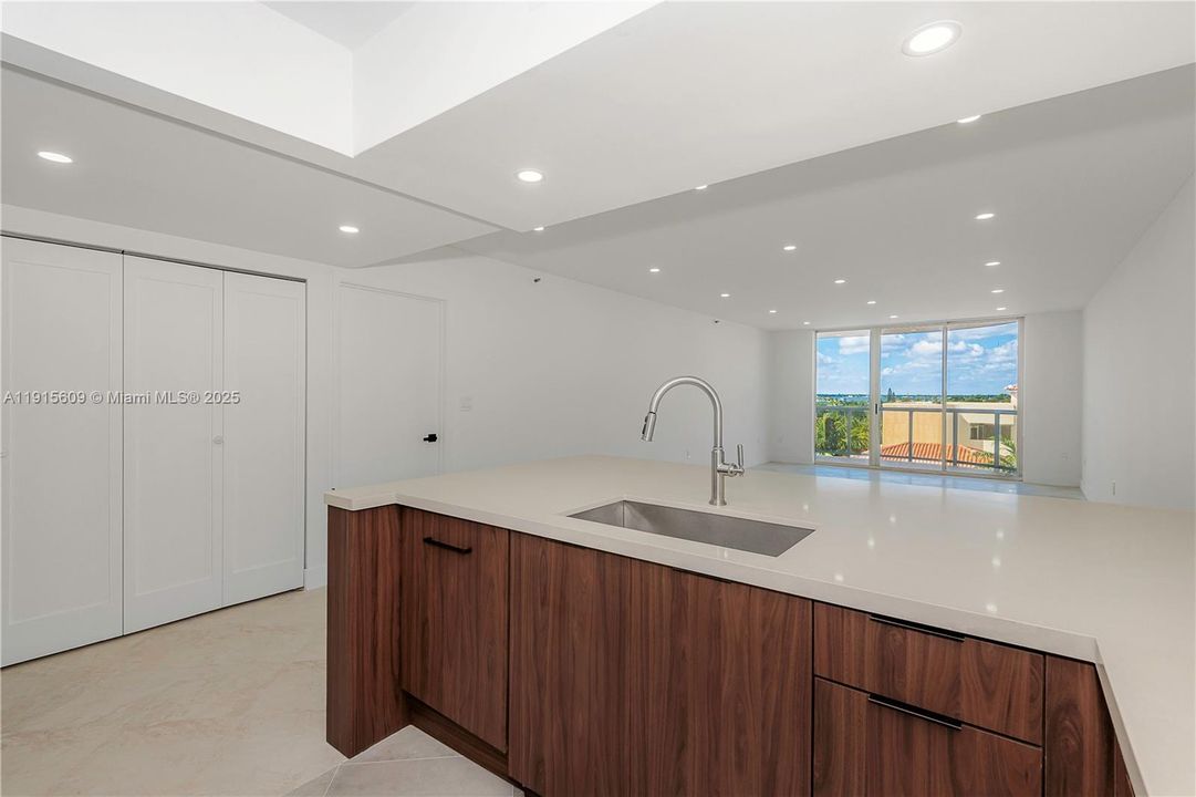 open kitchen next to large double closet/pantry