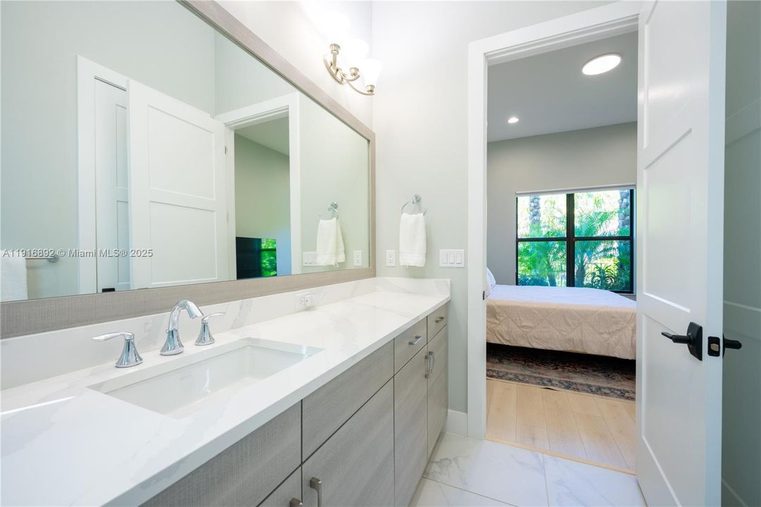 Downstairs suite with a  lengthy quartz vanity in gorgeous bathroom