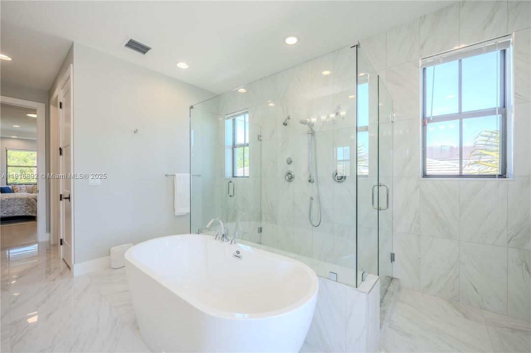 Luxurious master bathroom with freestanding tub and dual shower