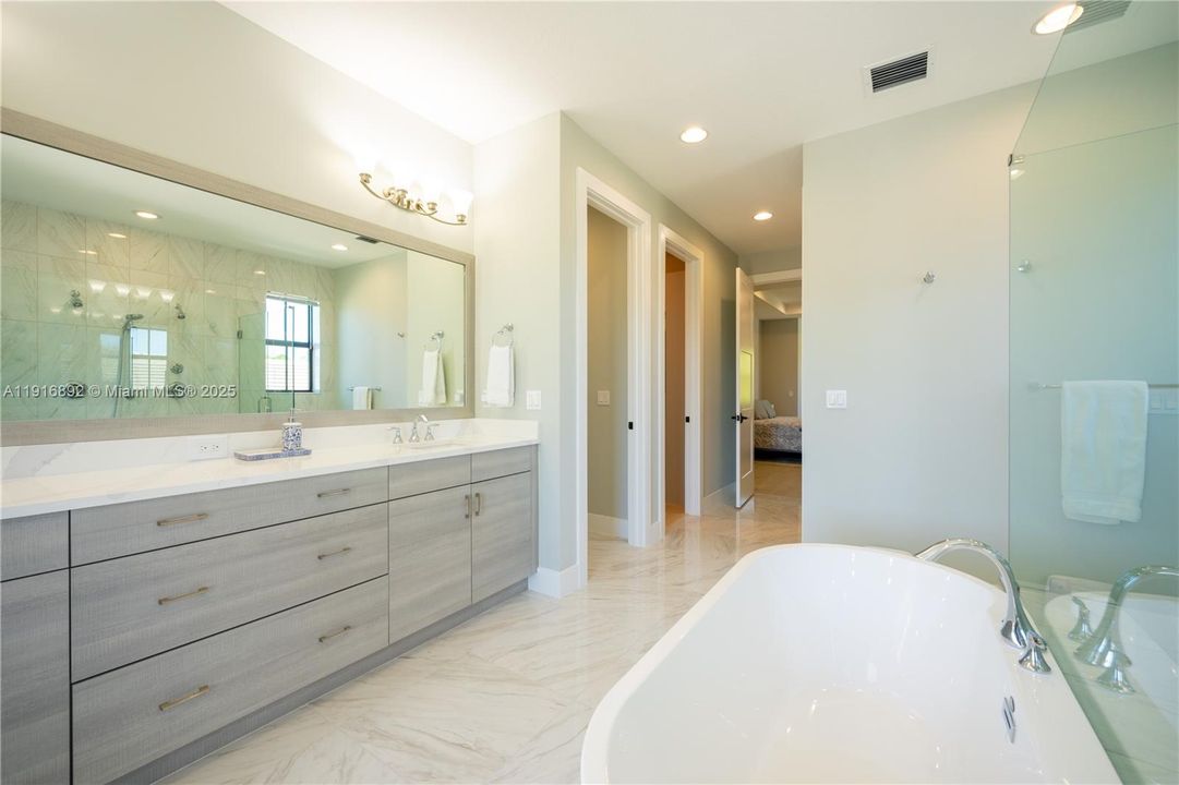 Master suites large vanity with a free standing tub and plenty of storage
