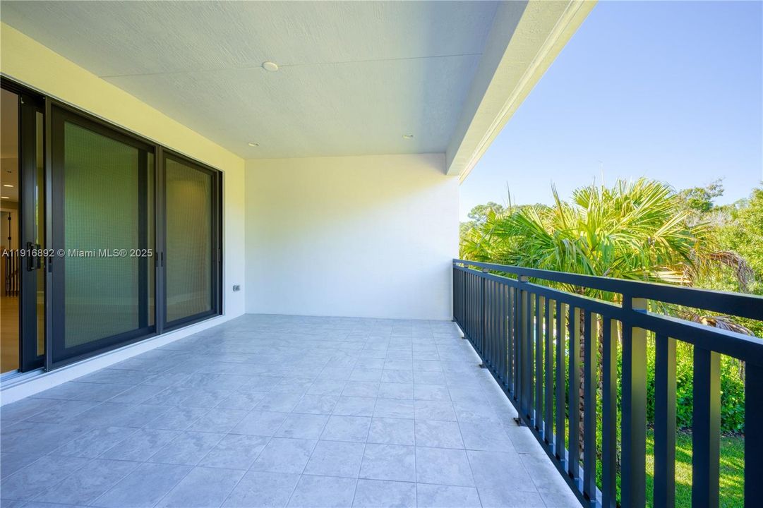 Large upstairs balcony overlooking the tall palm trees