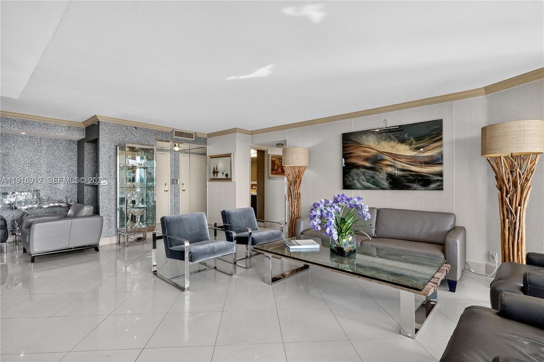 An open, sun-filled living space with floor-to-ceiling views that capture both the tranquil waterfront and the vibrant skyline