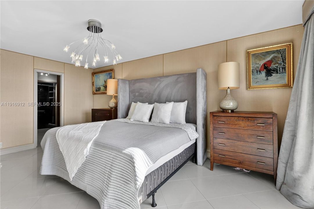 The primary bedroom offers an expansive, light-filled retreat with sweeping views of Miami’s skyline and the sparkling waterfront