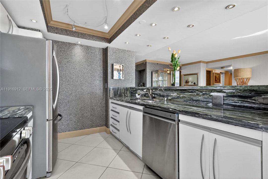 A beautiful, light-filled kitchen features striking emerald-green granite countertops that bring a rich, natural elegance to the space