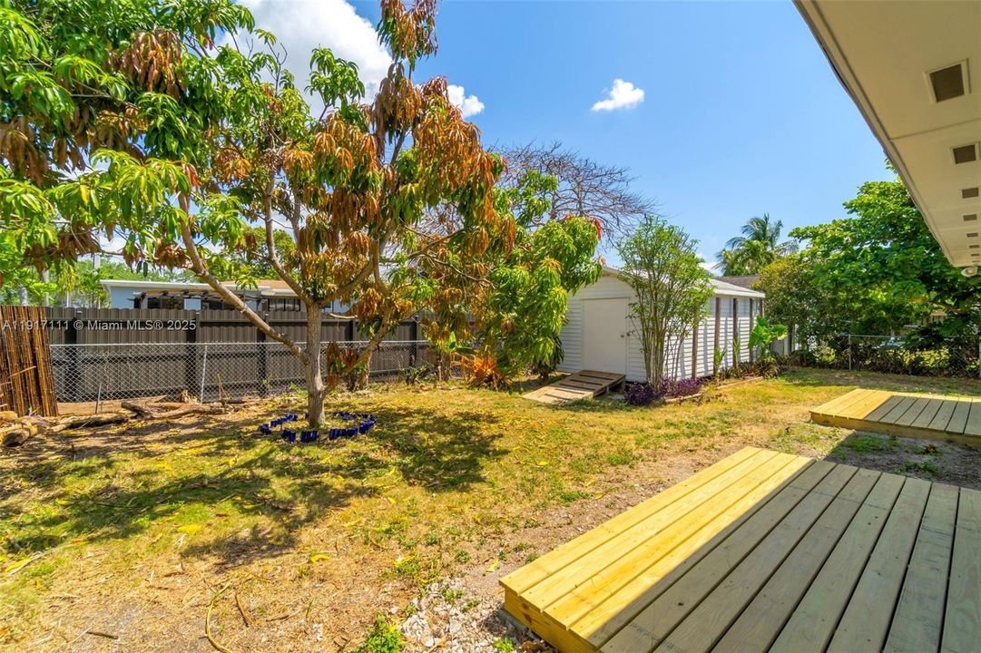 BACKYARD WITH TWO DECKS OFF OF THE DINING ROOM & PRIMARY BEDROOM W/ ASSORTED FRUIT TREE'S