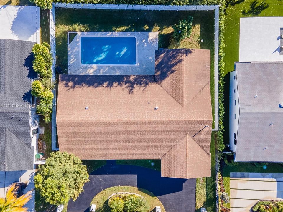 Aerial overhead view showcasing the full property layout, large pool area, and fenced backyard.