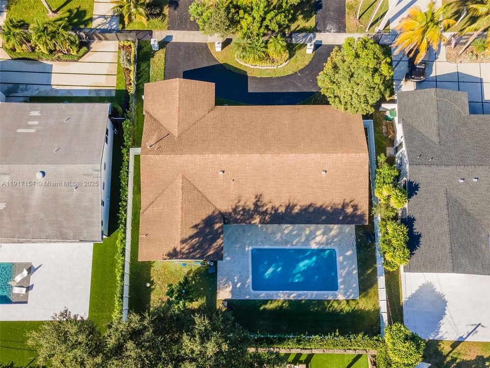 Aerial view highlighting the roofline, large pool deck, and privacy fencing on all sides.
