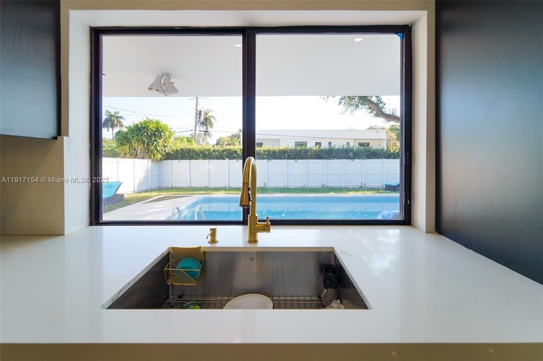 Kitchen window overlooking the backyard and pool for easy indoor–outdoor connection.